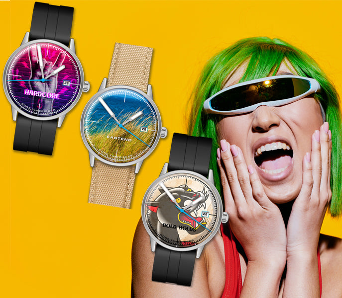 Three watches with different designs on a yellow background, with a person wearing green hair and sunglasses in the foreground.