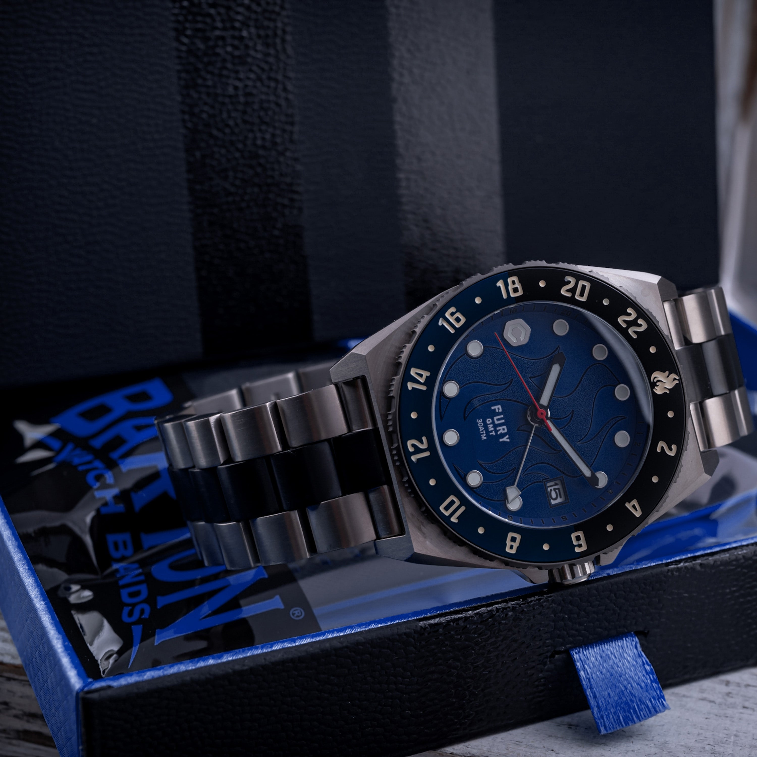 titanium automatic watch with dark blue flame dial sitting in box